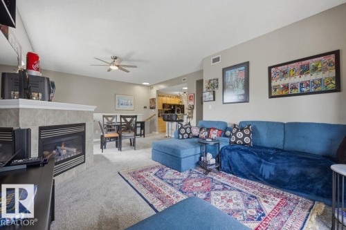 Living area featuring a gas fireplace with a tiled surround and mantel - 71 3040 Spence Wynd, Edmonton, AB 