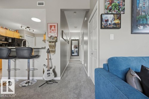 Kitchen pass-through featuring an extended countertop bar with seating - 71 3040 Spence Wynd, Edmonton, AB 
