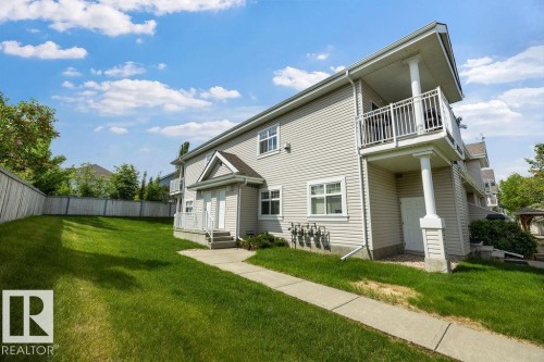 Modern multi-story structure with light-colored siding, featuring a second-story balcony with white railing, a ground-level patio, and a front entry with a small porch - 71 3040 Spence Wynd, Edmonton, AB 