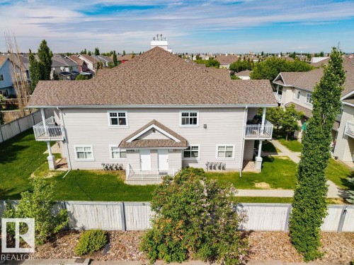 Two-story property featuring light-colored siding and a gabled roof - 71 3040 Spence Wynd, Edmonton, AB 