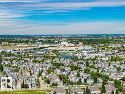 Expansive aerial perspective showcasing a residential neighborhood with numerous single-family homes and mature trees - 71 3040 Spence Wynd, Edmonton, AB 