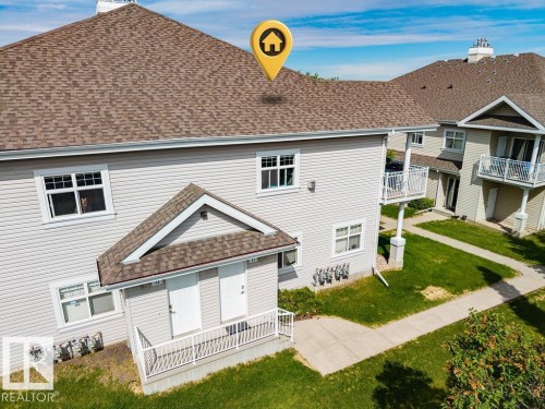 Exterior featuring light-colored siding, multiple windows, and a brown shingle roof - 71 3040 Spence Wynd, Edmonton, AB 