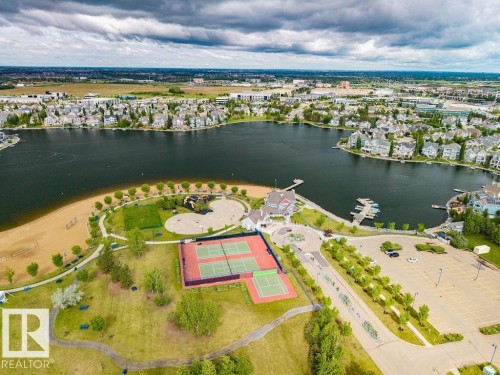 Expansive community lakefront featuring a sandy beach, multiple tennis courts, and a marina with boat slips - 71 3040 Spence Wynd, Edmonton, AB 