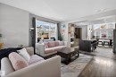 Open-concept living area featuring wood-finish flooring, a large window, and recessed lighting - 9847 220 Street, Edmonton, AB 