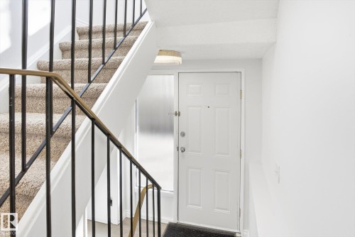 Inviting entryway featuring a white paneled door, frosted sidelight, and flush-mount ceiling light - 857 Erin Place, Edmonton, AB 