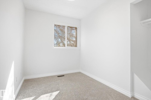 Bright room featuring a window with white trim, light-colored carpeting, white walls, and white baseboards - 857 Erin Place, Edmonton, AB 