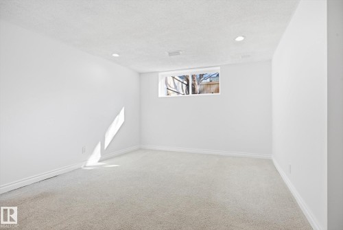 Crisp white walls define this room featuring light-colored carpeting and a window - 857 Erin Place, Edmonton, AB 