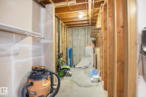 Unfinished basement space with exposed wooden framing, concrete flooring, and visible ceiling joists - 857 Erin Place, Edmonton, AB 
