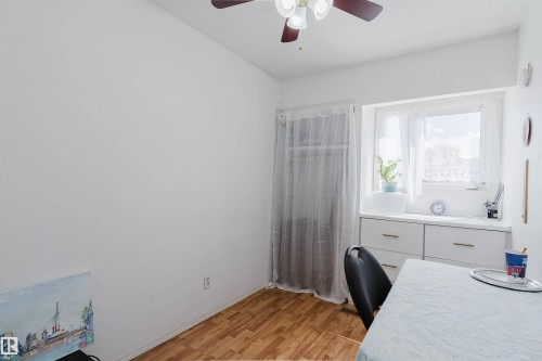Room featuring wood-finish flooring and a ceiling fan with integrated lighting - 4 14310 80 Street, Edmonton, AB 