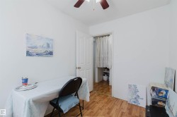 White walls featuring wood-finish flooring and a ceiling fan - 