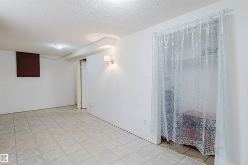 Finished room featuring neutral wall paint, tile flooring, and a flush-mount ceiling light - 4 14310 80 Street, Edmonton, AB 