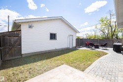 Detached garage with white siding, a small window, and a side access door - 