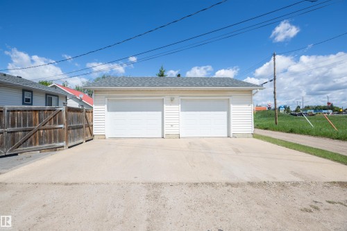 Detached two-car garage with white vinyl siding and a gray shingled roof - 10232 101 Street, Westlock, AB 