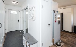 Entryway featuring a white paneled door with decorative glass insert, dark hardware throughout, and a flush-mount ceiling light - 