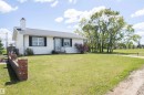 White vinyl-sided residence with dark shutters and a light-colored roof - 10232 101 Street, Westlock, AB 