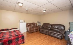 Neutral wall paint, wood-finish flooring, and a grid ceiling with flush-mount lighting fixtures - 