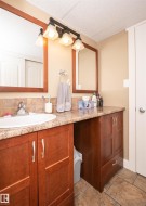 Bathroom featuring wood-finish cabinetry, a drop-in sink, and a speckled countertop - 