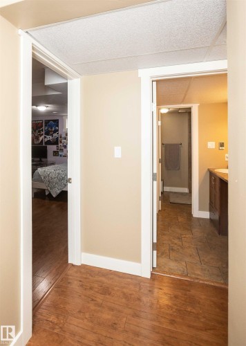 Hallway featuring wood-finish flooring, neutral wall paint, and white trim - 10232 101 Street, Westlock, AB 