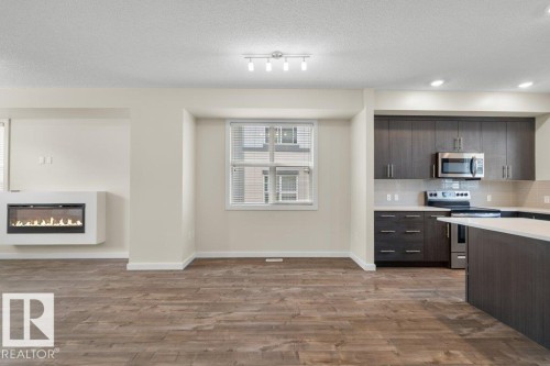 Open-concept living space with wood-finish flooring - 125 655 Watt Boulevard, Edmonton, AB 