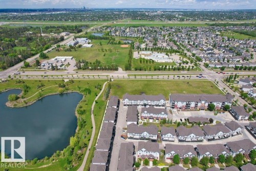 Aerial perspective showcasing a residential area with a prominent pond feature - 125 655 Watt Boulevard, Edmonton, AB 