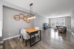 Open-concept living space featuring wood-finish flooring, recessed lighting, and multiple windows - 