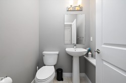 Pedestal sink with chrome faucet, wall-mounted mirror, and overhead vanity lighting - 