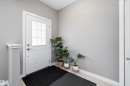 Entryway featuring a white door with divided light window, brushed nickel hardware, and light-toned tile flooring - 8412 24 Avenue, Edmonton, AB 