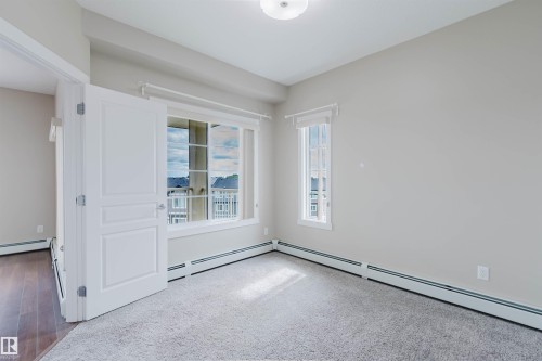 Carpeted room with a large multi-pane window and a secondary vertical window - 402 3670 139 Avenue, Edmonton, AB 