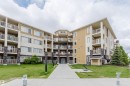 Multi-story building exterior featuring a neutral color palette, stone accents, and multiple private balconies with white railings - 402 3670 139 Avenue, Edmonton, AB 