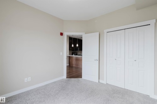 Neutral-toned room featuring light gray carpet flooring and white trim - 402 3670 139 Avenue, Edmonton, AB 