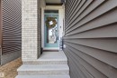 Entryway featuring a light blue front door, concrete steps, and a complementary brick facade - 1471 Plum Circle, Edmonton, AB 