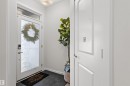 Entryway featuring a full-light door with transom window, white trim, and a flush-mount ceiling light fixture - 1471 Plum Circle, Edmonton, AB 