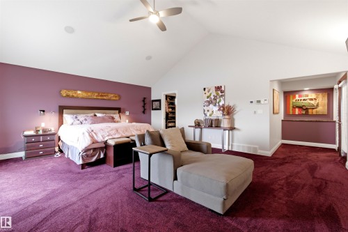 Bedroom featuring a vaulted ceiling with a ceiling fan, purple accent wall, and purple carpeting - 9003 16 Avenue, Edmonton, AB 