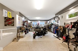 Spacious garage featuring a durable speckled epoxy floor, recessed lighting, and multiple windows for natural illumination - 