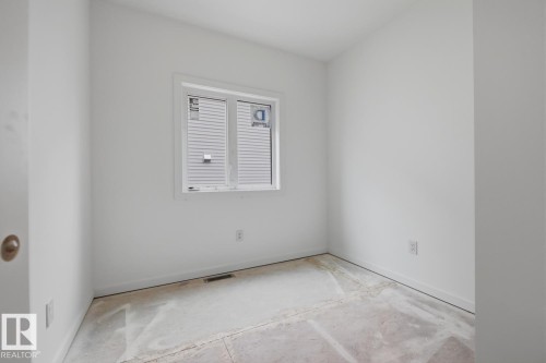 Bright interior space featuring a window with integrated blinds, white walls, and a subfloor ready for finishing - 11327 122 Street, Edmonton, AB - Indoor Photo Showing Other Room