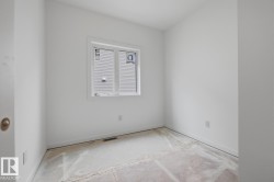 Bright interior space featuring a window with integrated blinds, white walls, and a subfloor ready for finishing - 