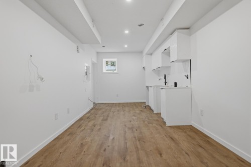 Open-concept living space featuring wood-finish flooring, recessed lighting, and a window for natural illumination - 11327 122 Street, Edmonton, AB - Indoor Photo Showing Other Room