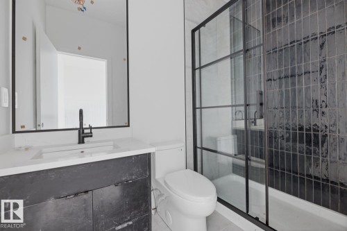 Bathroom featuring a black frame vanity mirror, dark wood-finish vanity, integrated sink with matte black faucet, and a black grid-style glass shower enclosure - 11327 122 Street, Edmonton, AB - Indoor Photo Showing Bathroom