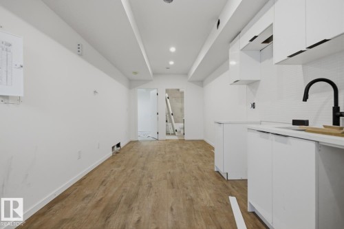 Kitchenette area featuring white flat-panel cabinetry, white countertops, and a subway tile backsplash - 11327 122 Street, Edmonton, AB - Indoor Photo Showing Other Room