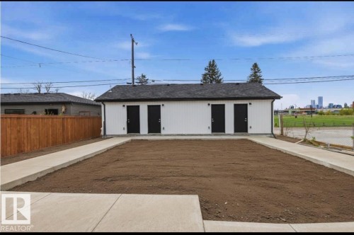 Detached structure featuring white siding, a dark shingle roof, and two black exterior doors - 11327 122 Street, Edmonton, AB - Outdoor