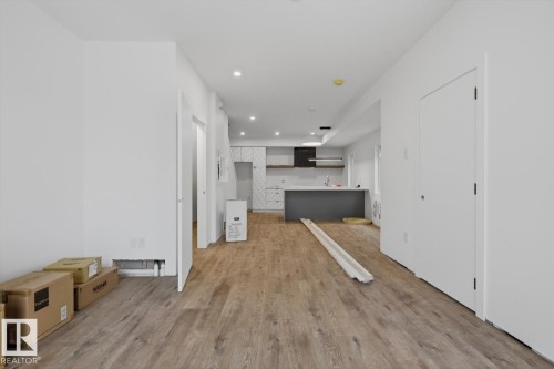 Open-concept living space with wood-finish flooring extending into the kitchen - 11327 122 Street, Edmonton, AB - Indoor