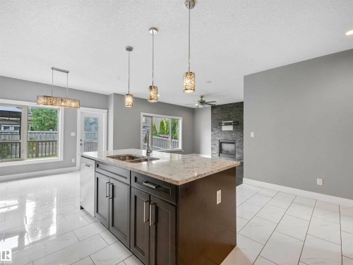 Kitchen island with integrated sink, stone countertop, and pendant lighting - 1090 Armitage Crescent, Edmonton, AB 