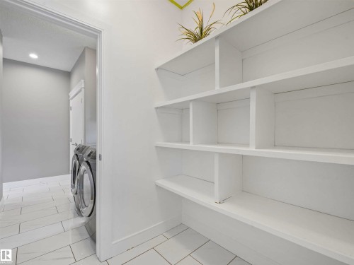 Laundry area featuring built-in shelving, tile flooring, recessed lighting, and a neutral color palette - 1090 Armitage Crescent, Edmonton, AB 