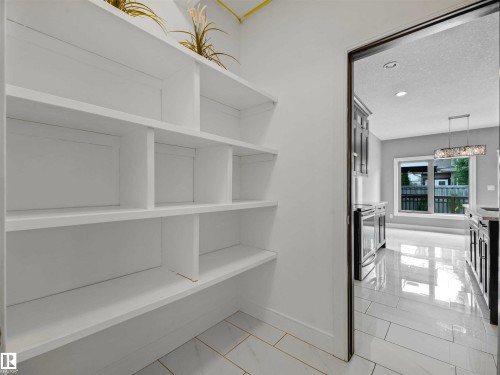 Pantry space featuring extensive white shelving and tile flooring - 1090 Armitage Crescent, Edmonton, AB 