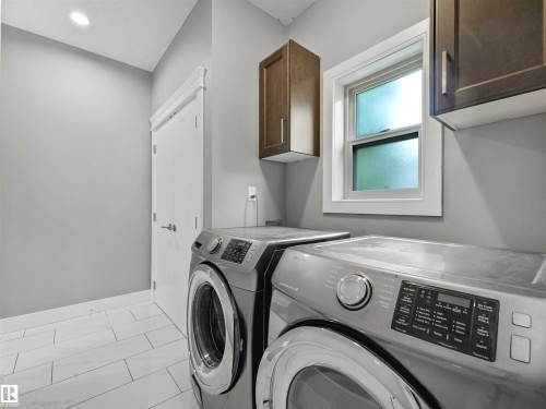 Laundry room with white rectangular tile flooring, recessed lighting, and a double-hung window - 1090 Armitage Crescent, Edmonton, AB 