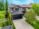 Two-story residence featuring light-colored siding with dark trim accents and a dark shingle roof - 1090 Armitage Crescent, Edmonton, AB 