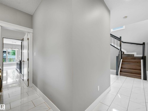 Foyer featuring light gray walls, white baseboards, and glossy white rectangular tile flooring - 1090 Armitage Crescent, Edmonton, AB 