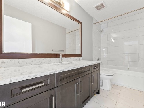 Double vanity with a stone countertop and rectangular undermount sinks - 1090 Armitage Crescent, Edmonton, AB 