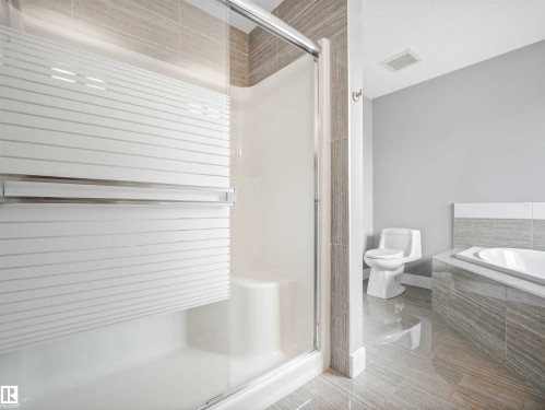 Modern bathroom featuring a glass-enclosed shower with frosted striped accents - 1090 Armitage Crescent, Edmonton, AB 