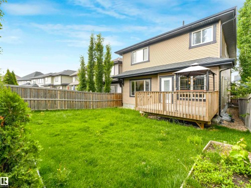 Expansive backyard featuring a wood deck, full perimeter fencing, and mature landscaping - 1090 Armitage Crescent, Edmonton, AB 